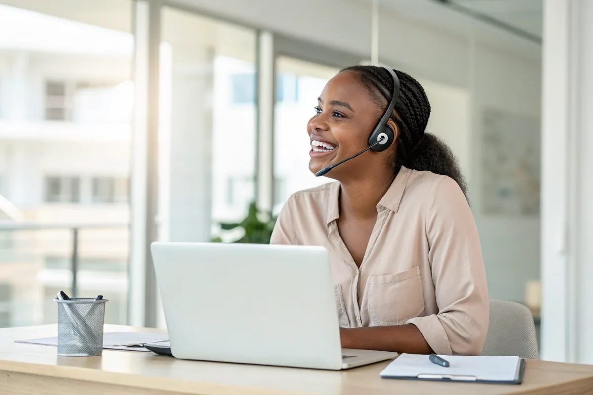A CASH ZA support agent at her desk, listening to a customer.